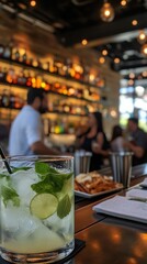 A bartender preparing a mojito behind a sleek bar counter as patrons chat in the background.