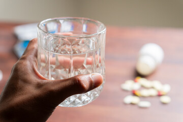 Scattered Pills and Syringe on Wooden Table