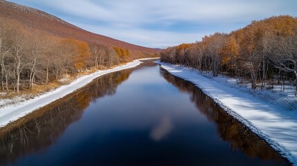 Aerial View of Calm River Reflecting Winter Landscape with Snow and Autumnal Trees