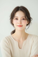 Fototapeta premium Elegant Young Woman in Soft Pastel Dress with Natural Makeup