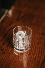 Crystal clear ice cube in a glass on a bar