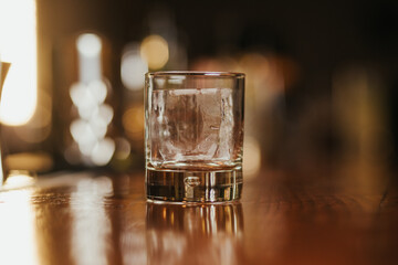 Crystal clear ice cube in a glass on a bar