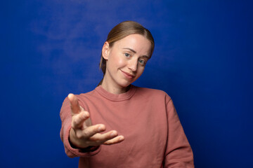 blonde woman smiling, looking happy, confident and friendly, offering a handshake to close a deal,...