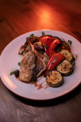Restaurant dish fish with vegetables: zucchini, pepper