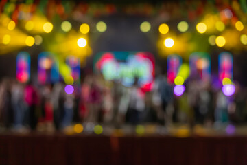 Blurred concert stage with colorful lights and crowd