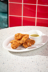 Portion of golden fried chicken with sauce in the cafe