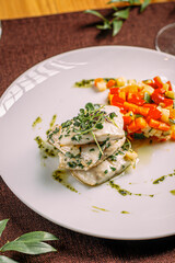 Portion of gourmet white fish with sauted vegetables