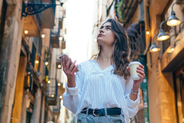 Pensive woman drinking coffee on street in town