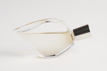 Leaf-shaped clear perfume bottle with silvery cap.
