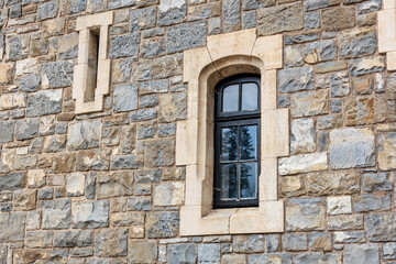Historic stone castle wall with arched window and rustic architecture
