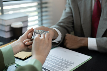A man and a woman are sitting at a table with a judge. The man is handing the woman a piece of paper
