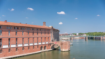 Naklejka premium Aerial hyperlapse of Toulouse's historic Hotel Dieu Saint-Jacques by the Garonne River, France.