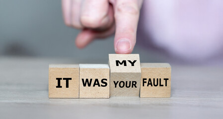 Hand turns cube and changes the expression 'it was your fault' to 'it was my fault'.