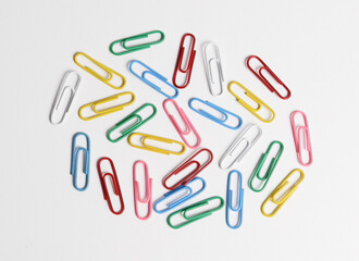 Colorful paper clips made of galvanized steel wire and plastic on white background.