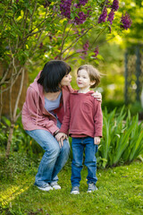 Fototapeta premium Cute big sister cuddling with her toddler brother. Adorable teenager girl hugging her small sibling. Children exploring nature.