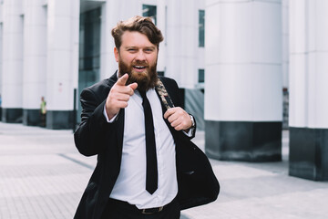 Happy smiling employee actively gesticulating while walking along street