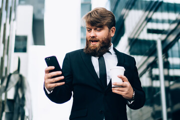 Confident businessman using smartphone on city street