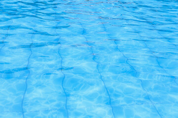 Tranquil blue water surface with gentle ripples in a sunny pool