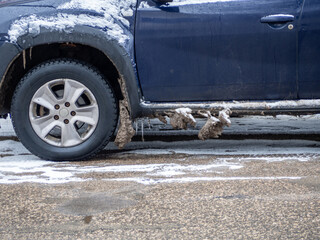 Car with frozen mud and ice. The effect of salt on the car body. Bad driving conditions in winter....