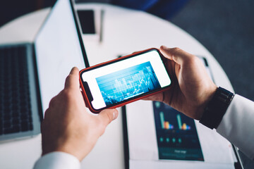 Unrecognizable businesspeople browsing gadgets while working