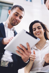 Cheerful diverse colleagues working on tablet