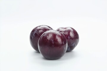 Fototapeta premium Fresh and juicy plum trio on clean white background showcasing vibrant colors and textures for healthy eating choices