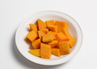 Cut mango fruit on a white plate.
