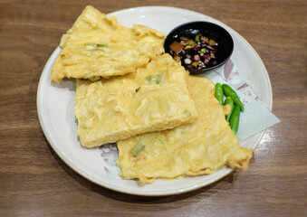 Tempe Mendoan, an Indonesian traditional snack made from tempe or tempeh (fermented soybeans) coated in flour and spring onions and fried half-cooked.