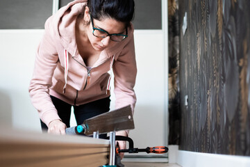 Woman sawing wood for home skirting board