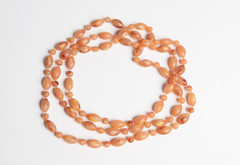 Oval beads loose necklace in earth tone color on white background.