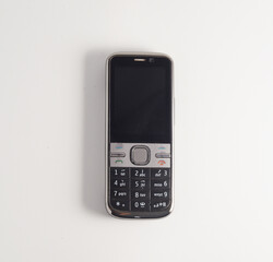 Old mobile phone with black screen, isolated on white.