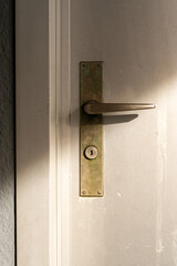 Modern door with door handle of an outside door. Traces of weathering.  Vertical photograph.