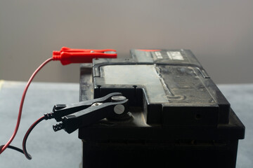 Charging car battery with electric current. Electrical charging Cables on a 12 volt Battery