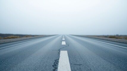 Asphalt road vanishing into a hazy horizon, suggesting a journey and open road ahead