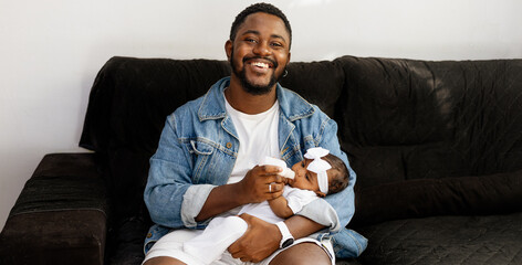 A happy young black father having moments of affection and care with his newborn daughter. Rio de...