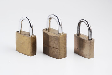 Three mall old solid brass padlocks, isolated on white.