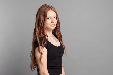 Teenage girl with long hair on light grey background. Space for text