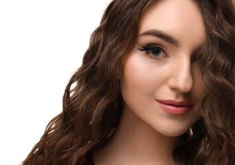 Fototapeta premium Beautiful young woman with long curly brown hair on white background, closeup