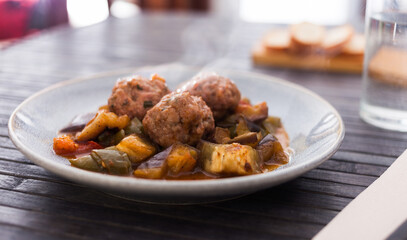 Cooked meatballs with smoky stewed eggplant in a bowl