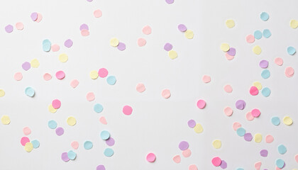 Playful pastel confetti scattered on light table, celebration joy