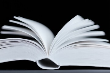 Obraz premium capture close-up of open book with soft lighting highlighting pages emphasizing textures and inviting viewer to imagine