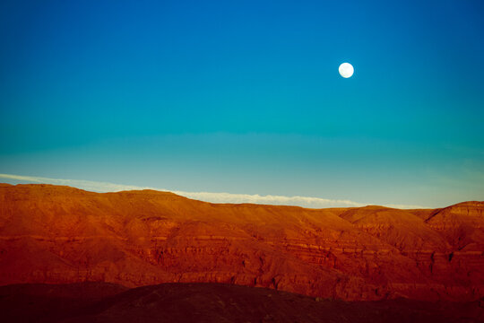 Full moon over a mountain landscape along the River Nile, Egypt