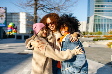 Three women embracing and sharing a joyful moment together