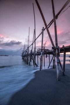 Receding water by a Bamboo pier on a beach at sunrise, Tanjung Kait, Mauk District, Tangerang Regency, Banten, West Java, Indonesia
