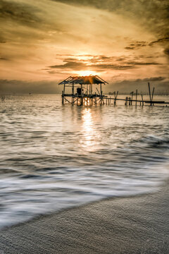 Receding water by a Bamboo pier on a beach at sunrise, Tanjung Kait, Mauk District, Tangerang Regency, Banten, West Java, Indonesia