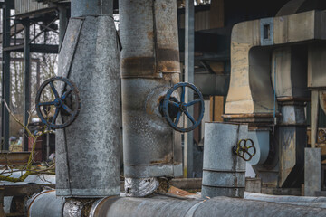 heating network, heat network, pre-insulated pipes, heat supply pipeline covered with bushes going up. old abandoned boiler room of closed production plants. rusty, damaged pipes. valves. industrial a