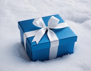 A beautifully wrapped blue gift box with a white ribbon sits on a bed of fluffy white snow.