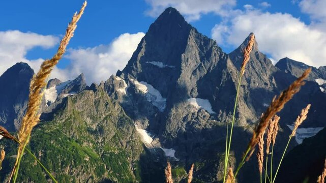 Teberdinsky Nature Reserve. View of Kosygin's glade in the Gonachkhir gorge and the top of Dombai-Ulgen mountain near Lake Tumanly-Kel on a sunny summer day. Panoramic landscape. Resort. 4K