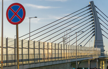 construction of a steel bridge over the road and railway tracks. metal bridge arch. modern...