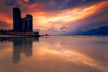 Silhouette of waterfront skyscrapers and cranes at sunset, Ajman, UAE